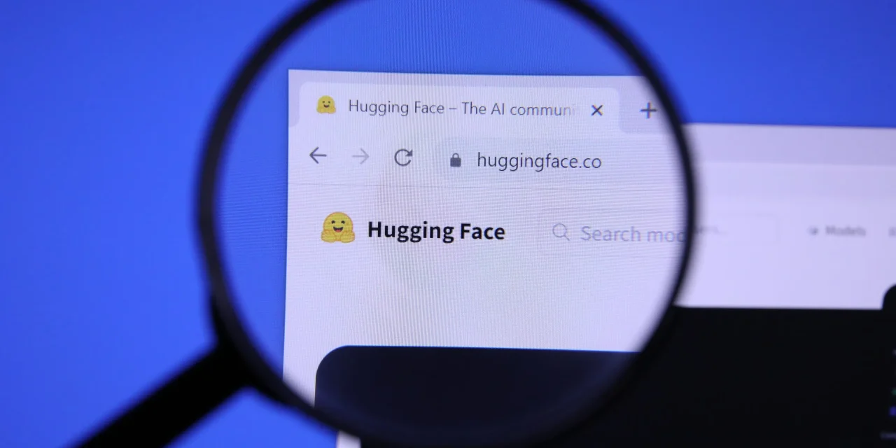 Página de inicio de Hugging Face aumentada sobre el logotipo con lupa, plataforma creadora de Text Generation Inference (TGI) para servir modelos de lenguaje abiertos