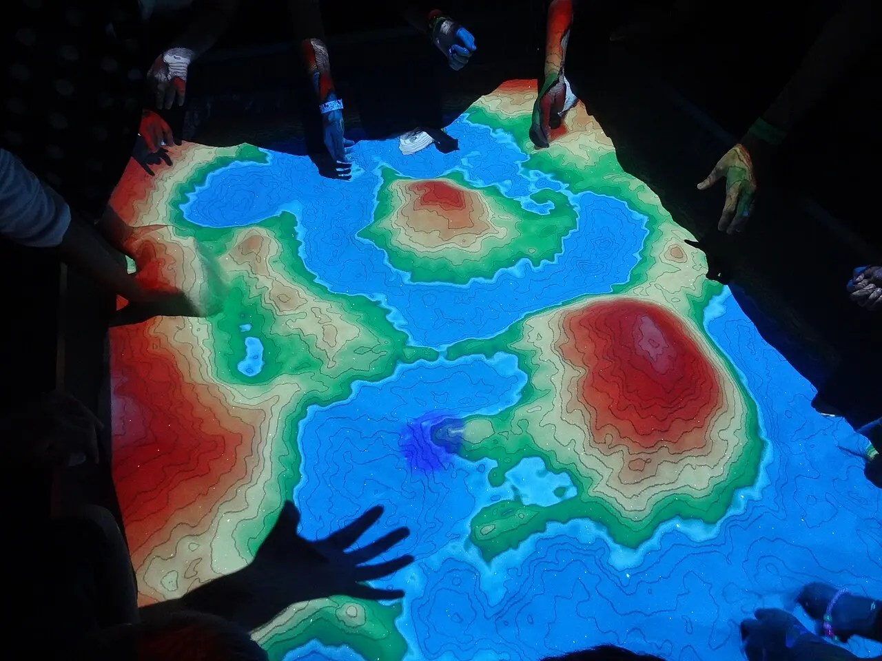 Augmented reality installation at the Perot Museum projecting geological information over physical sand in real time