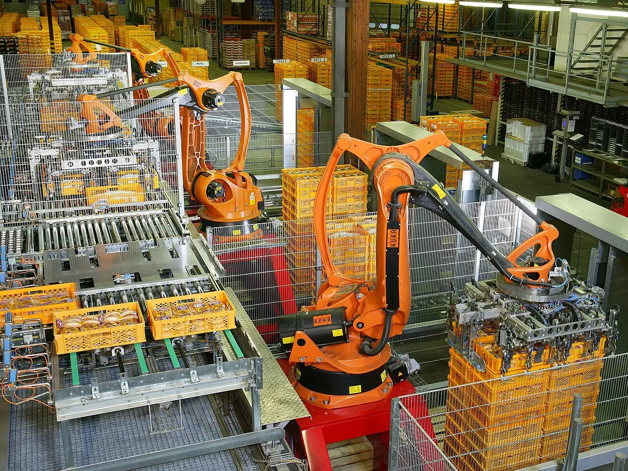 Industrial automation line with robotic arms palletizing bread, showing the type of repetitive, low-changeover process where the dark factory model makes the most economic sense